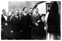 Lou Zanoni, age 5, at family wedding with brothers and cousins, peeking out at the camera